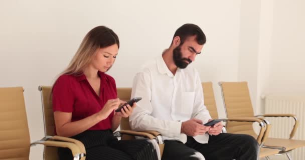 Två Klienter Använder Smartphone Väntrummet Moderna Prylar Och Tillämpningar — Stockvideo