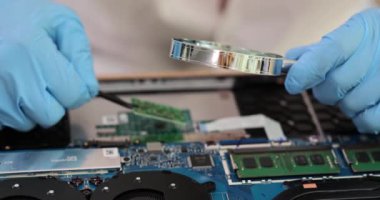 Bilgisayar anakartındaki çip büyüteçle yakınlaşıyor. Anakart onarım kavramı