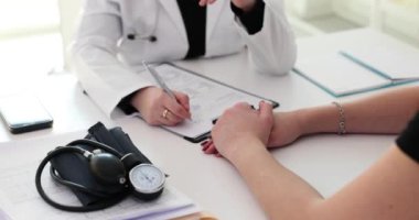 Doktor, kliniğe sempati duymak ve cesaretlendirmek için hastanın eline dokunuyor. Hasta ve kötü haberleri destekle ve cesaretlendir.