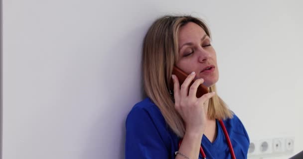 紧张的女医生坐在医院走廊的地板上 手持手机 坏消息和医生疲劳 — 图库视频影像
