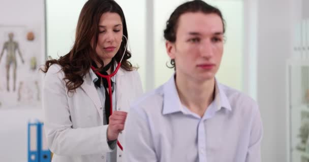 Terapis Mendengarkan Napas Pria Remaja Dengan Stetoskop Dokter Wanita Yang — Stok Video