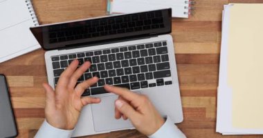 İş adamı iş yerinde oturur ve parmaklarına güvenir ve dizüstü bilgisayarda bir konferans düzenler. Uzak çalışma ve danışma