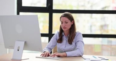 Kadın işçiler klavyede iş yerindeki meslektaşlarına el sallayarak veri yazıyor. Profesyonel iş akışı ve ofiste ağır çekimde dostça bir jest.