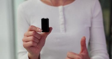 Genç bir kadın elinde pil tutuyor ve baş parmağını hareket ettiriyor. Kadın, standart pil özelliklerini, dayanıklılığını ve çevre korumasını vurguluyor
