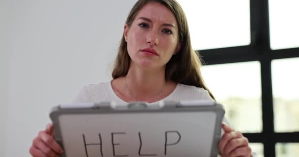Kimerült Kis Táblát Emel Segítség Szóval Fiatal Fáradt Arckifejezéssel Asztalnál — Stock videók