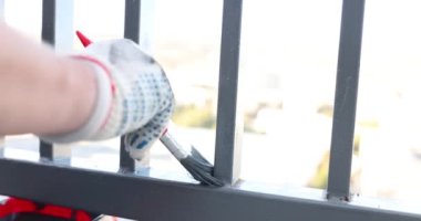 Pamuk eldivenli servis çalışanı titizlikle balkonun köşelerini ince boya fırçasıyla yavaş çekimde boyuyor. Tecrübeli bir ustanın mükemmel işi
