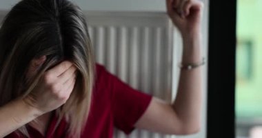 Merkezi ısıtma radyatörüne kelepçelenmiş ağlayan kadın ağır çekimde. Kaçırılan kadın içeride kalorifere kelepçelenmiş bir şekilde zorla ağlıyor. Başı dertte olan kadın