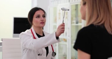 Kadın doktor, parlak hastanenin ofisindeki kadın tepkisini kontrol ediyor. Tıbbi enstitüdeki nörologla randevudaki kontroller yoluyla teşhisi öğrenmek