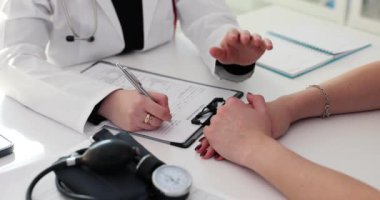 Kadın doktor, hastanede hastanın tedavi için kontrat imzalamasını destekliyor. Ciddi hastalıkların tedavisinde başarı elde etmeye çalışıyorum. Belgeler tamamlanıyor
