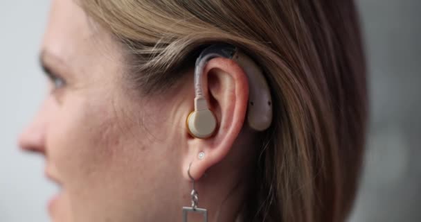 成熟した女性は新しい補聴器をテストします 耳の聞こえない女性は 新しい補聴器を通して医師の声を聞くと幸せに笑います 補助デバイスのコンセプトのテスト — ストック動画