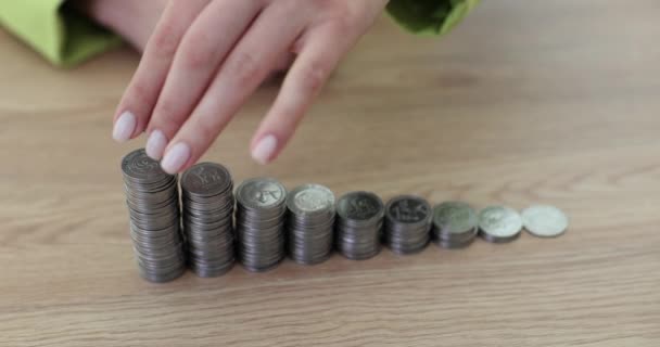 女性従業員は オフィスの木のテーブルに現金の梯子にコインを置きます 企業のスローモーションにおける仕事と利益成長の成功 — ストック動画