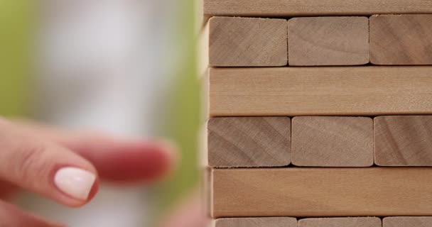 Woman Hand Takes Accurately Wooden Board Out Fragile Tower Playing — Stock Video