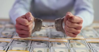 Kelepçeli ve Amerikan doları olan bir iş kadını. Dolandırıcılık ve vergi kaçakçılığı