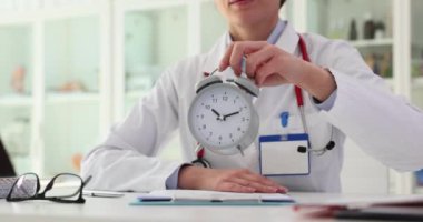 Klinikteki doktorun elindeki çalar saat. Tıbbi muayene zamanlaması ve zamanlaması