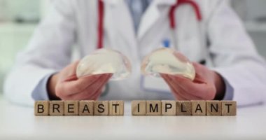 Doktor göğüs büyütme için silikon implantlar tutuyor. Plastik cerrah elleri silikon göğüs implantı ve estetik cerrahi tutuyor.