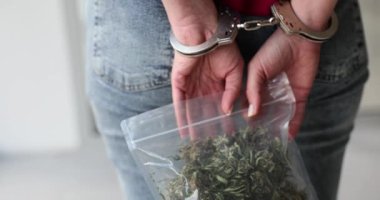 Kelepçeleri ve bir çanta marihuanayı teslim et. Uyuşturucu satıcısı kelepçeyle tutuklandı