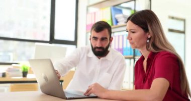 Çeşitli ortaklardan oluşan bir ekip masada oturmuş dizüstü bilgisayarla projeyi tartışıyorlar. İki profesyonel iş adamı birlikte çalışıyor.