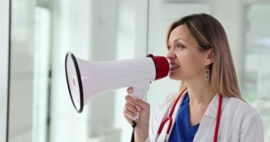 Kadın doktor megafonla duyuru yapıyor. Tıbbi hizmetler ve önleme