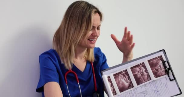 烦躁不安的医生读坏消息 检查超声波图像 冻结和未发育的怀孕 — 图库视频影像
