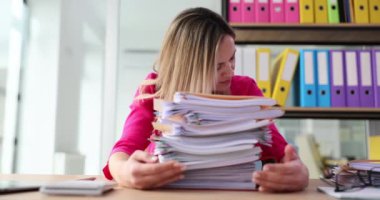 Dosyaları olan üzgün kadın masada uyuyor. İş yerinde yorgun ve bitkin bir iş kadını.