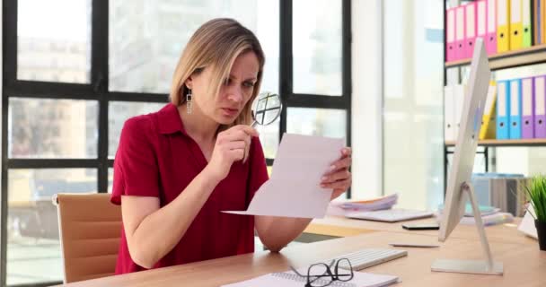 视力不好的女商人使用放大镜在办公室工作和阅读文件 成人视力问题 — 图库视频影像