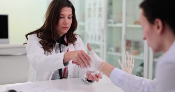 Молодой Раненый Болью Руке Посещает Травматолога Женщина Врач Накладывает Эластичную — стоковое видео