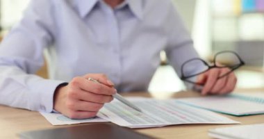 Finans masalarında çalışan iş kadını elinde gözlük tutuyor. Bildirimde güvenilmez göstergeleri tanımlamanın yolu