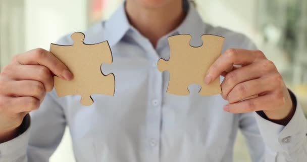 女性の手で結合する2つのパズルピースのクローズアップ ビジネスパートナーを探す — ストック動画