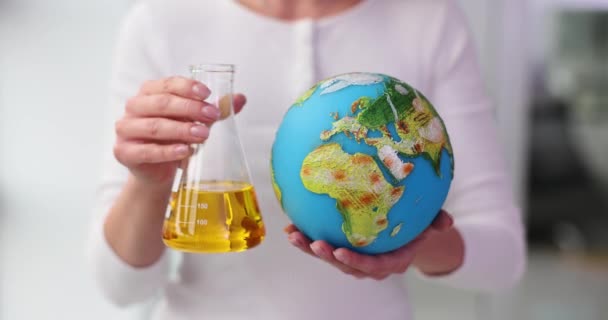 Scientist Holds Flask Yellow Oil Globe Geographical Features Oil Industry — Stock Video