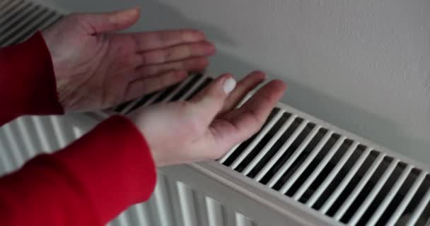 手は寒い冬に暖かいラジエーターと家に触れる スチームラジエーター暖房チューブをチェック — ストック動画