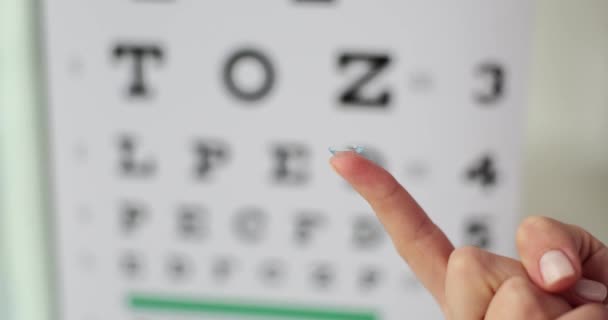 眼科医のテーブルの閉鎖の背景に対する女性の指のコンタクトレンズ 医学とビジョンコンセプト — ストック動画