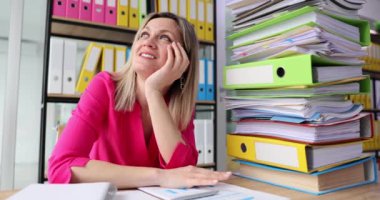 Hayalperest genç kadın, fikirler üzerine kafa yoruyor masada kağıtlarla oturuyor. Genel sekreterin dikkati monoton işlerden dağılıyor.