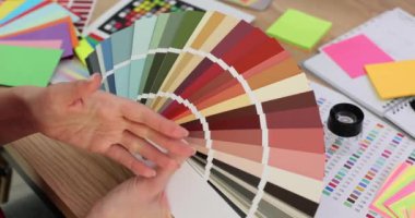 Ofisteki tasarımcı palette renk örnekleriyle çalışıyor. İç kısımdaki renkler seçiliyor