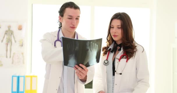 Kvinnlig Kirurg Visar Resultaten Röntgen Till Manlig Traumatolog Kliniken Läkarkollegor — Stockvideo