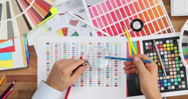Mężczyzna Projektant Gospodarstwa Szkło Powiększające Próbki Kolorów Przy Wyborze Koloru — Wideo stockowe
