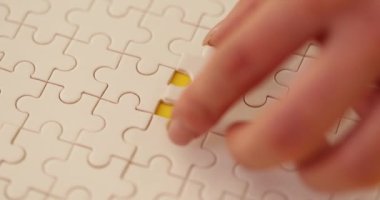 Yapbozun son parçasını tamamlayan resme monte eden kadının eli. Çocuk ve yetişkinler için düşünme becerilerini geliştirmek için tasarlanmış bir oyun
