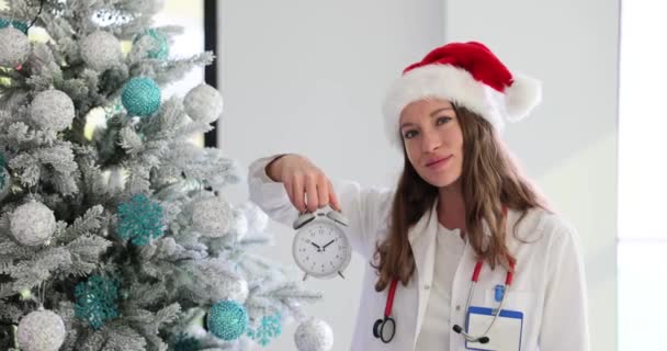 Woman Doctor Santa Hat Holds Alarm Clock Signalling Time Holiday — Stock Video