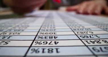 Sekreter, ofis numaraları ile şirket atıkları hakkında önemli verileri vurgulamak için pembe kalem kullanıyor. İş yerindeki şirket için muhasebe defteri.