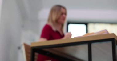 Buruşmuş kağıt parçası oda çöp sepetine düşüyor. Arka planda bulanık kadının attığı katlanmış kağıt parçası çöp kutusuna düşüyor.