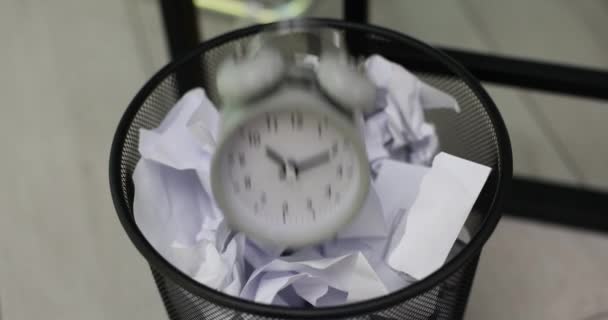 会社の従業員は会社のオフィスの職場で粉砕された文書の束が付いているゴミにヴィンテージ警報時計を投げます 不要で古いものを取り除く — ストック動画