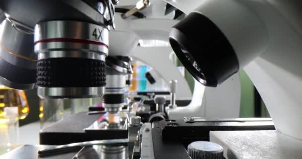 显微镜放在实验室的桌子上 旁边是实验室助理正在研究的化学品 生物实验室配备了强大的显微镜以深化知识 — 图库视频影像