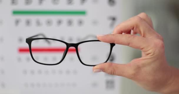 视力差的人选择眼镜 可以清楚而清晰地看到世界 人们举起眼镜试图在Snellen测试图上看到字母 — 图库视频影像