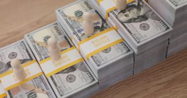 İnsan figürleri para birikintilerinden yapılmış merdivenin tepesinde, kırmızı lider figürleri en yüksek konuma yerleştiriliyor. İlgi çekici yönetim kavramı