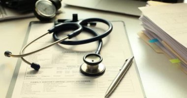 Doktor muayenehanesindeki tıbbi kayıtlarda steteskop ve tükenmez kalem var. Hastanedeki terapist masasında hasta geçmişi olan bir muayene aleti. Sağlık hizmetleri