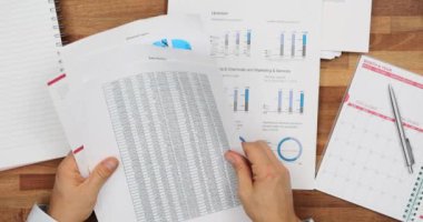 Erkek müdür, raporları masada kontrol ediyor. Muhasebeci şirket belgelerini işyerindeki verilerle birlikte inceliyor. Şirket bilgileri