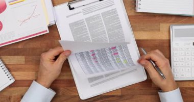 Ortak kontrolleri raporlar ve imza kontratları masada. Şirket erkek patronu ofis işyerinde geliştirme planlı kağıtları onaylıyor. Şirket stratejisi