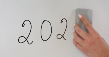 Kadın geçen yılın son rakamını siliyor ve beyaz tahtaya yeni yazılar yazıyor. Bayan ofiste iş yılının değiştiğini belirtiyor. Zaman yönetimi