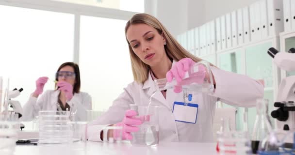 Femme Verse Liquide Dans Une Fiole Contre Collègue Laboratoire Chimique — Video