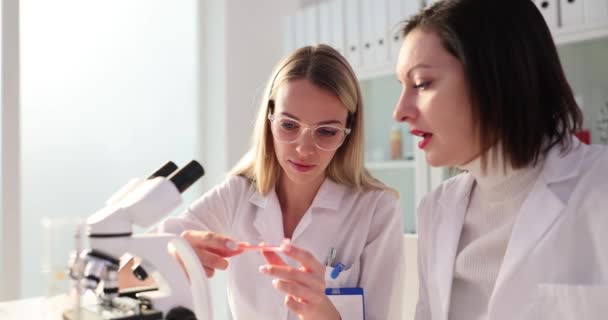 Las Mujeres Examinan Sustancia Naranja Una Pequeña Placa Petri Laboratorio — Vídeos de Stock