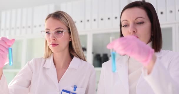女性生物学者は試薬を混合して青色を作り 検証された色は期待される組成と一致した 実験の正確性を検証する — ストック動画